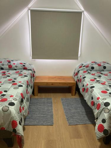a room with two twin beds and a bench at Casa Relmu in Puerto Varas