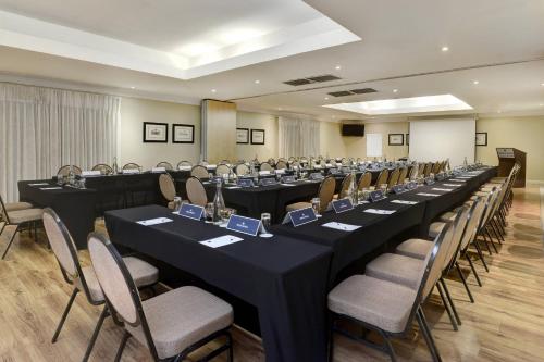 a conference room with long tables and chairs at Protea Hotel by Marriott Mahikeng in Mahikeng