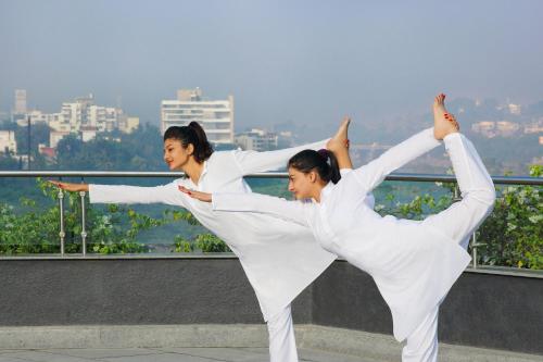 two women in white dancing on a rooftop at The Westin Pune Koregaon Park in Pune