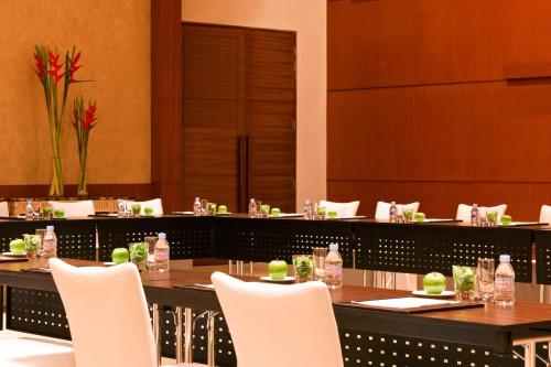 a dining room with a table and white chairs at The Westin Pune Koregaon Park in Pune
