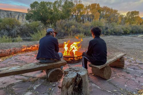 a group of three men sitting around a fire at Chinook Winds Lodge in Dubois
