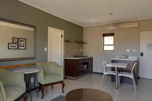 a kitchen with a table and chairs and a sink at Protea Hotel by Marriott Cape Town Durbanville in Bellville