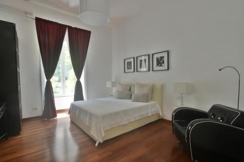 a white bedroom with a bed and a window at Piano Suite in Vatican in Rome