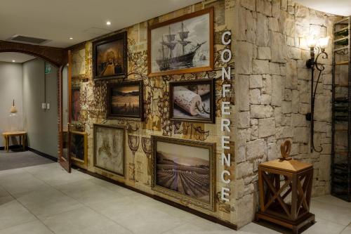 a wall with a bunch of pictures on it at Protea Hotel by Marriott Cape Town Durbanville in Bellville