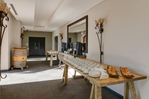 a room with a row of tables and a mirror at Protea Hotel by Marriott Cape Town Durbanville in Bellville