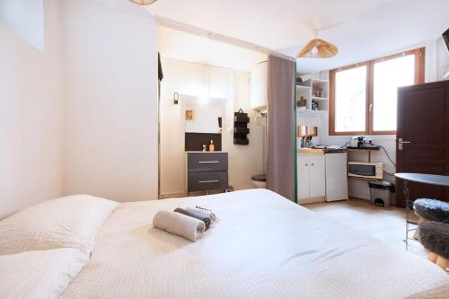 une chambre avec un lit blanc avec des serviettes dessus dans l'établissement La Loge Centrale Emplacement idéal Presqu'île Lyon, à Lyon