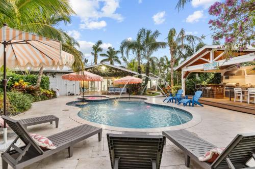 een zwembad met stoelen en parasols in een tuin bij Trophy Fish at the Oasis in Ellenton