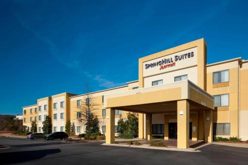 a large tan building with a parking lot at SpringHill Suites Columbus in Columbus