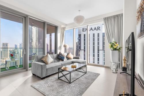 a living room with a couch and large windows at Luxury 4-Bed Escape in Downtown Dubai That Sleeps 9 in Dubai