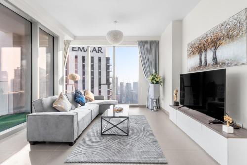 a living room with a couch and a tv at Luxury 4-Bed Escape in Downtown Dubai That Sleeps 9 in Dubai