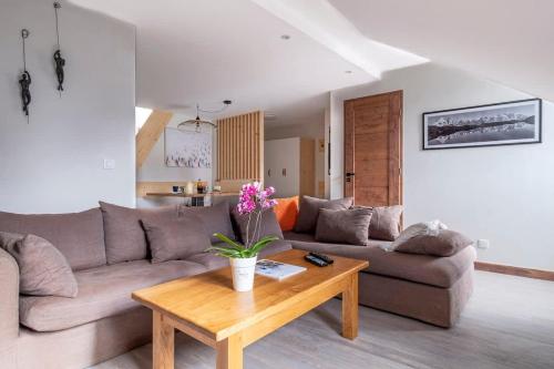 un salon avec un canapé et une table basse dans l'établissement L'Appart 52, magnifique duplex en plein coeur de Chamonix-Mont-Blanc, à Chamonix-Mont-Blanc