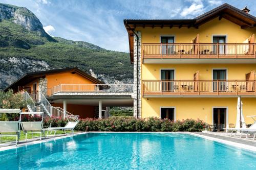 a hotel with a swimming pool in front of a building at Maso Agritur Santa Lucia in Dro
