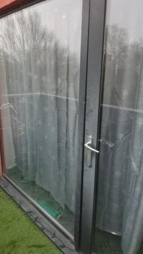 a sliding glass door with a view of trees at D'Chin Dorcelle Suite in Norbury