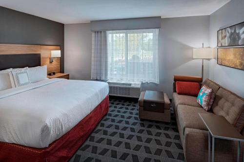 a hotel room with a bed and a couch at TownePlace Suites by Marriott Baton Rouge Port Allen in Port Allen