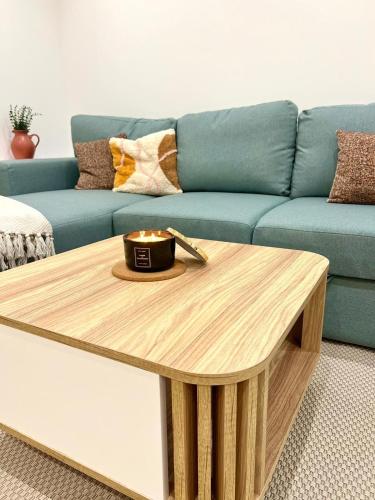 a living room with a blue couch and a coffee table at DisneyLand et Paris - Appartement Cosy in Noisiel