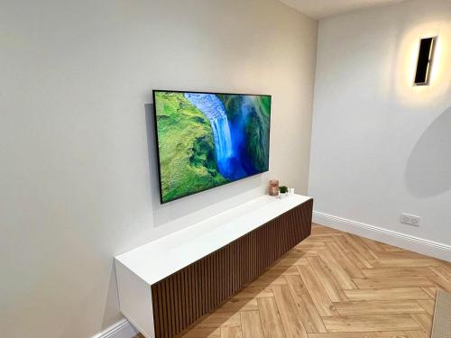 a television hanging on a wall in a room at DisneyLand et Paris - Appartement Cosy in Noisiel