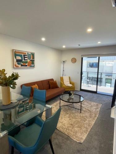 a living room with a couch and a table at Stylish and Sleek Auckland Stay in Auckland