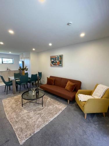 a living room with a couch and a table at Stylish and Sleek Auckland Stay in Auckland