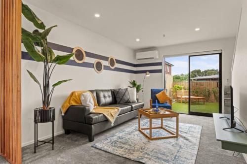 a living room with a couch and a table at 10 Te Kanawa Haven in Auckland