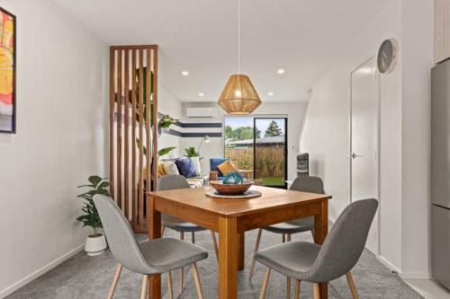 a dining room with a wooden table and chairs at 10 Te Kanawa Haven in Auckland