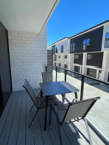 a patio with a table and chairs on a balcony at Urban Auckland Sanctuary in Auckland