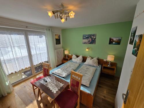 a small room with a bed and a table at am Mühlbach - Ferienwohnungen Luttinger in Bichlbach