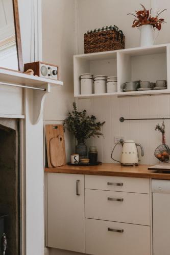 a kitchen with white cabinets and a counter top at Thagg Haus - Charming Miners Cottage in Wonthaggi in North Wonthaggi