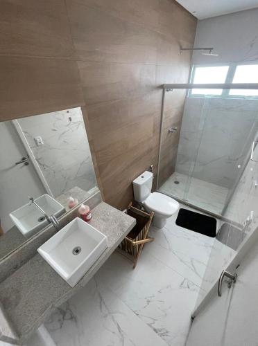 a bathroom with a sink and a shower and a toilet at Casa Beira Mar com Piscina Maragogi - Amar & Mar in Maragogi