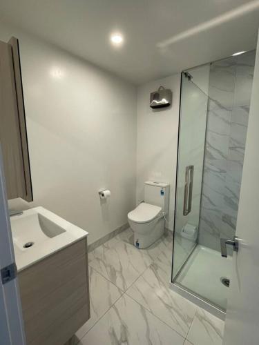 a bathroom with a toilet and a glass shower at Chic Auckland Getaway in Auckland