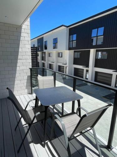 a table and chairs on the balcony of a building at Chic Auckland Getaway in Auckland