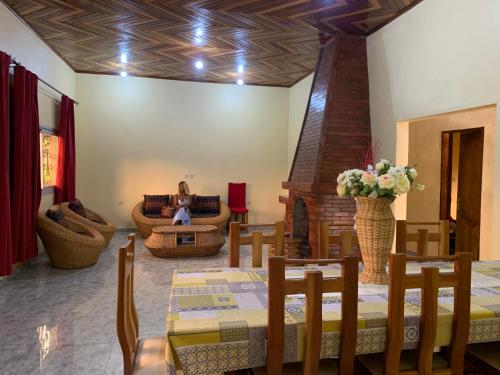 ein Wohnzimmer mit Tisch und Kamin in der Unterkunft Villa Serena in Bandjoun