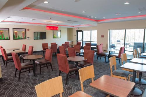 a dining room with tables and chairs and windows at TownePlace Suites by Marriott Battle Creek in Battle Creek