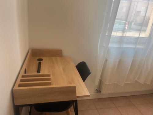 a wooden desk in a room with a window at Break Appart avec parking privé in La Celle-sous-Gouzon