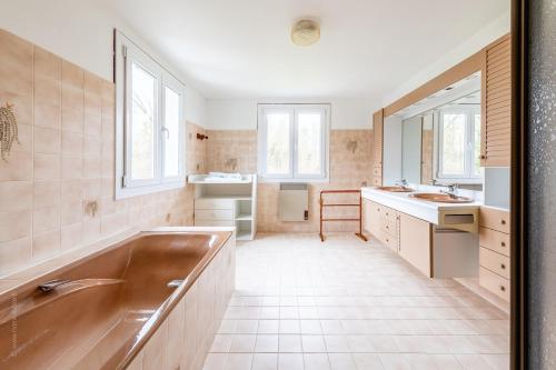 a bathroom with a tub and two sinks and a mirror at 300m2 house with large garden in Villuis