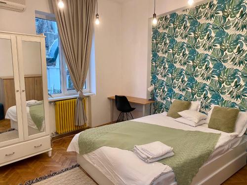 a bedroom with a bed with a green and white wallpaper at CoolKUSH 2U in Bucharest