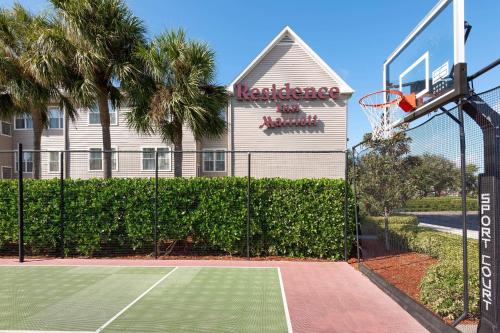 a tennis court with a basketball hoop in front of a building at Residence Inn by Marriott Fort Myers in Fort Myers