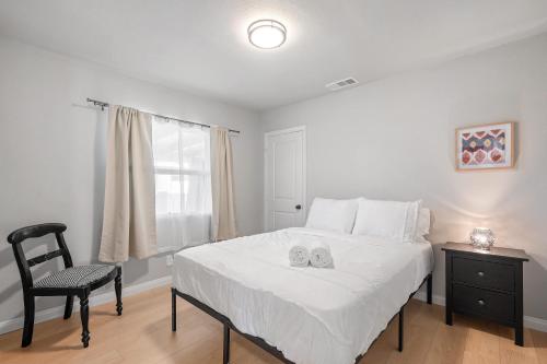 a bedroom with a bed and a chair and a window at Luxury Modern Retreat with Spacious Yard & Premium Comfort in Monrovia