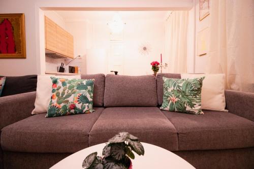 a living room with a brown couch with pillows at Lovely Flat in the Heart of Helsinki in Helsinki