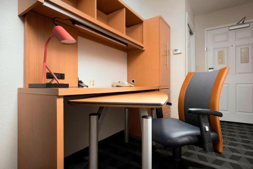 an office with a desk with a chair and a lamp at TownePlace Suites by Marriott Albuquerque Airport in Albuquerque