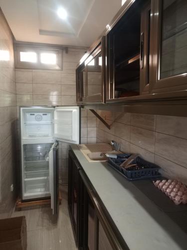 una cocina con estufa, refrigerador y mostrador en RDC Appart, en Lomé