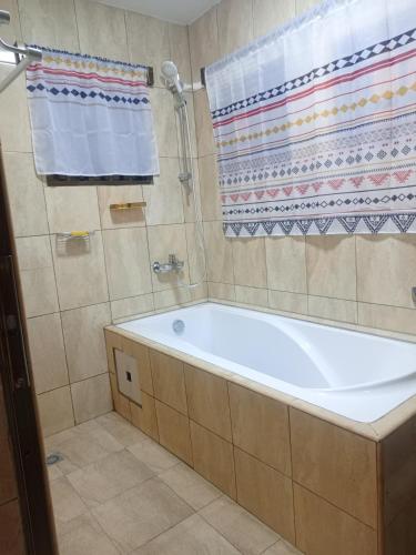una bañera en un baño con ducha en RDC Appart, en Lomé