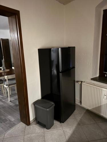 a black refrigerator in the corner of a room at Ferienwohnung Erzgebirgsglück OG in Jöhstadt
