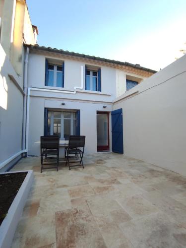 un patio avec des chaises et une table devant un bâtiment dans l'établissement Le Petit Gaffier, maison au pied de la Cité, avec 2 chambres et belle cour sans vis à vis, à Carcassonne