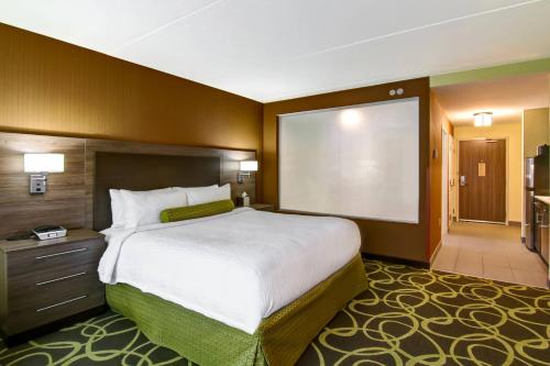 a bedroom with a large bed and a large screen at TownePlace Suites by Marriott Kincardine in Kincardine