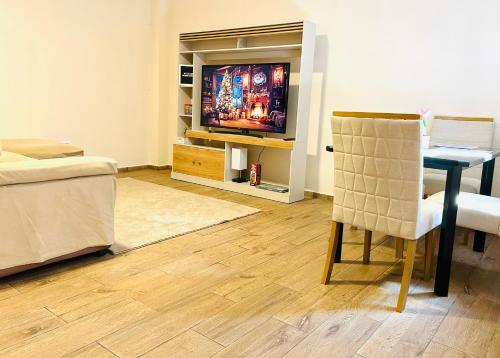 a living room with a television and a chair at Conchita's, near Mall metrocentro, AC, SHW in Santa Ana