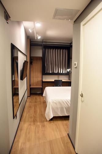 a bedroom with a white bed and a window at ibis Tangará Da Serra in Tangara da Serra