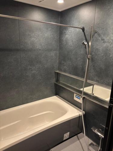 a bathroom with a bath tub and a shower at B-sum M-1 in Matsuzaka