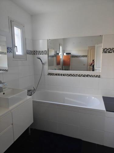 une salle de bain avec une baignoire, un lavabo et un miroir dans l'établissement Villa luxe 5 chambres piscine jacuzzi homegym, à Castelnau-le-Lez