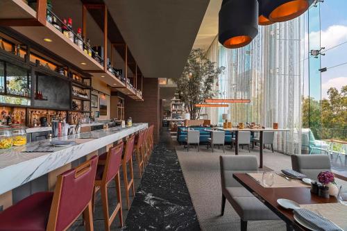 a restaurant with a bar with tables and chairs at The Westin Santa Fe, Mexico City in Mexico City