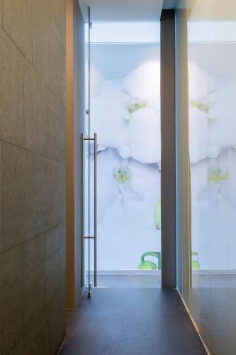 a hallway with an open glass door with a chair at The Westin Santa Fe, Mexico City in Mexico City